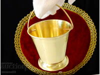 Brass cup with cauldron design.
