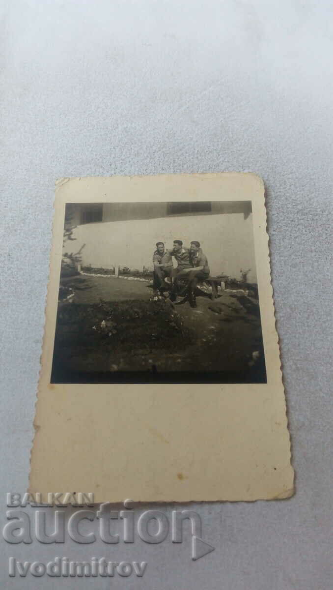 Photo Three soldiers sitting on a bench