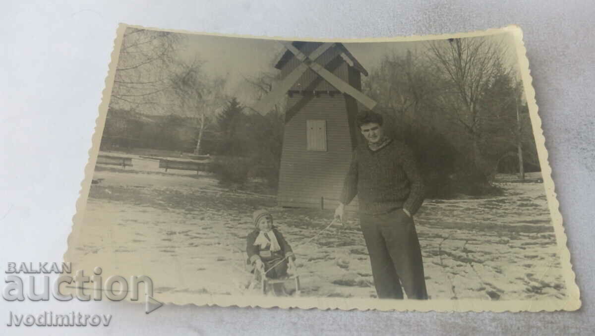 Снимка Мъж и момченце на шейна в парка