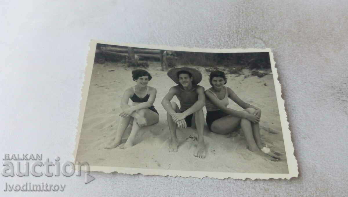 Fotografie Un tânăr și două fete pe plajă