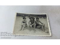 Photo A young man and two girls on the beach