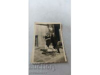 Photo A man, a woman and a baby in a vintage pram in front of their house