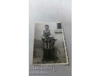 Photo A boy and a small dog on a wooden chair