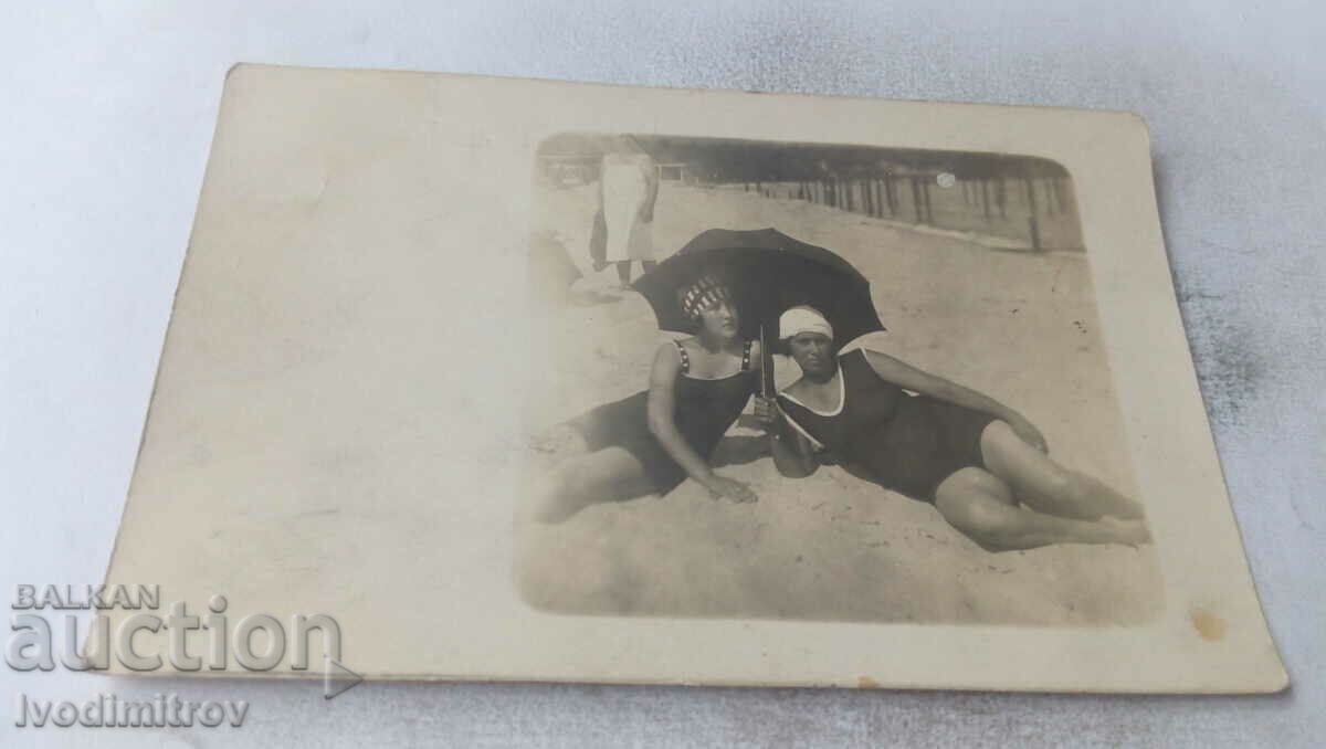 Fotografie Două tinere în costum de baie vintage cu umbrelă neagră pe plajă