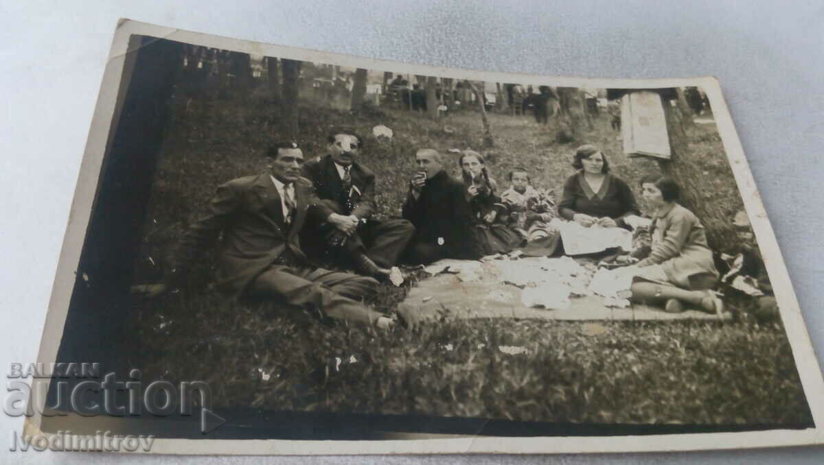 Picture Men and women and children on a picnic in the forest