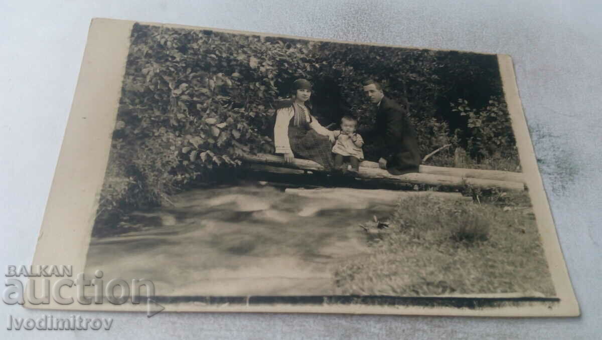 Снимка Мъж момченце и жева в народна носия на брод над поток