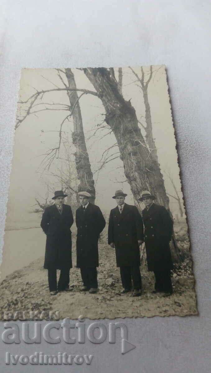 Fotografie Patru bărbați în haine de iarnă lângă râu