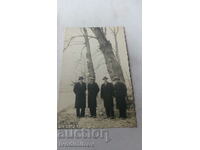 Photo Four men in winter coats by the river