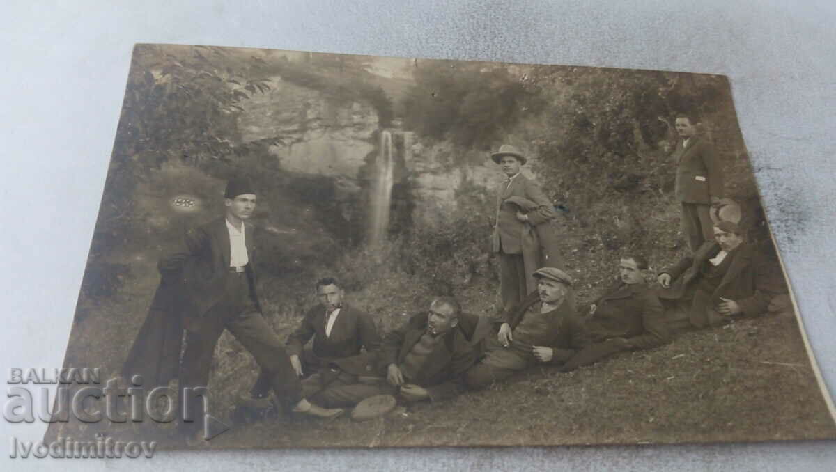 Photo Men in front of a waterfall