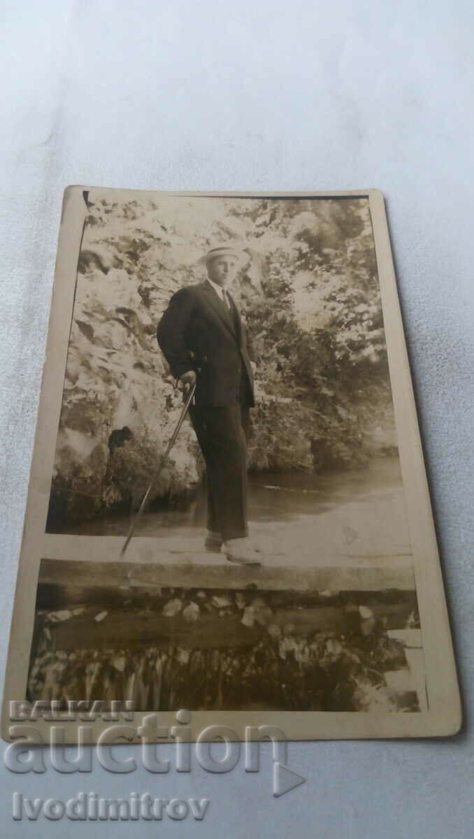 Fotografie Un bărbat cu un baston pe un baraj de pârâu