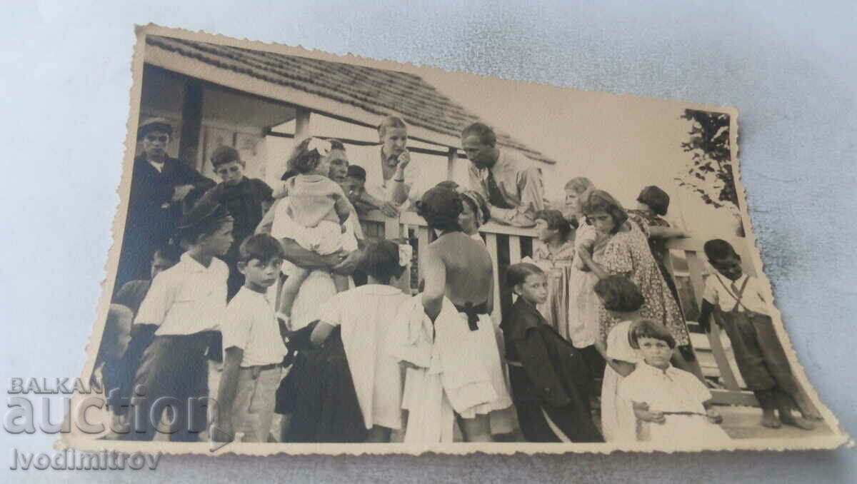 Fotografie Bărbați, femei și copii lângă un gard de lemn