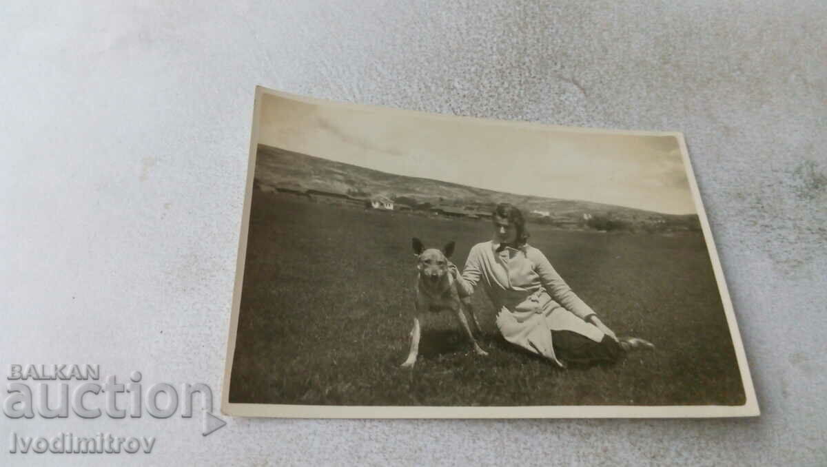 Снимка Млада жена с куче вълча порода на поляната