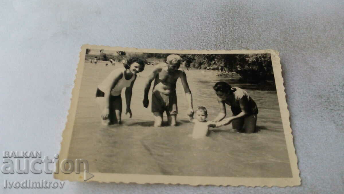 Picture A man, two women and a little boy in the river