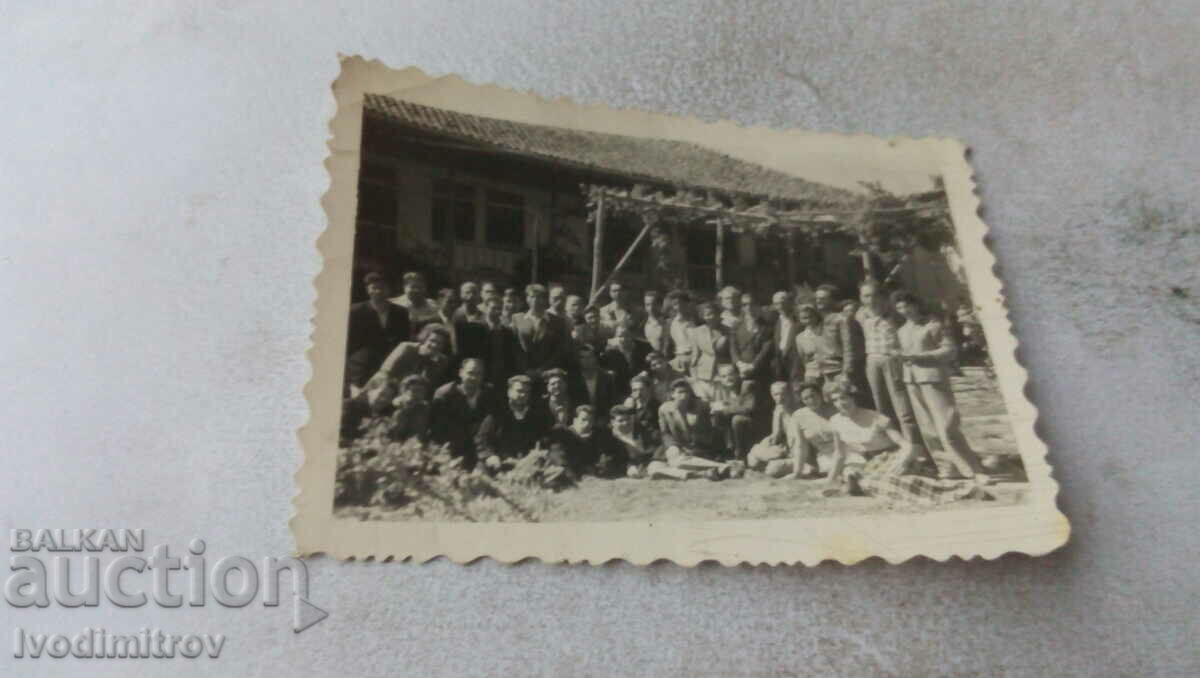 Photo Men and women in front of an old house