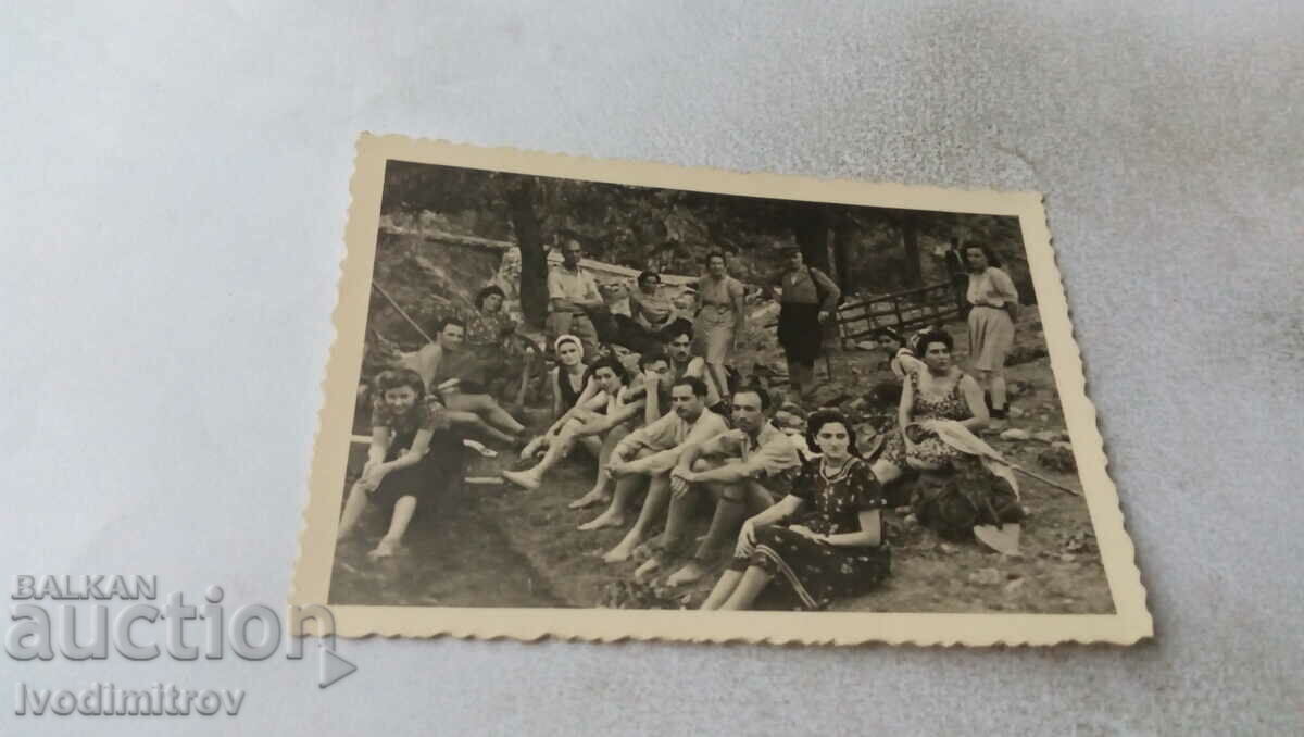 Photo Young men and women by a stream in the mountains