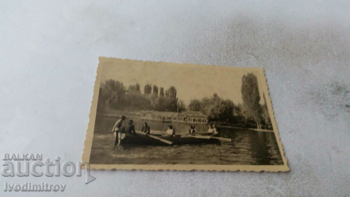 Photo Young men and women with a rowing boat in a lake