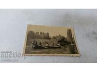 Photo Young men and women with a rowing boat in a lake