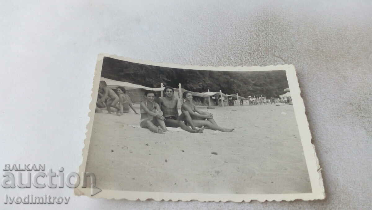 Снимка Млад мъж и две млади жени на плажа