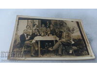 Picture Men and women having a drink around a table