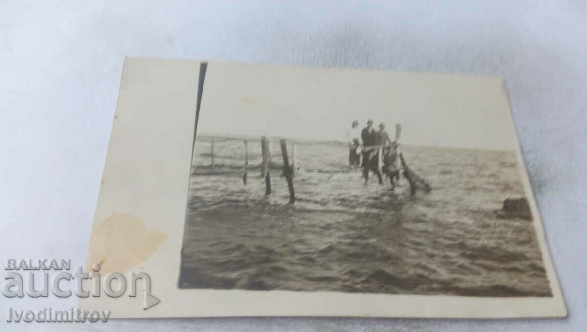 Φωτογραφία Άνδρες και ένα νεαρό κορίτσι σε μια ξύλινη προβλήτα στη θάλασσα