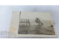 Photo Men and a young girl on a wooden pier in the sea
