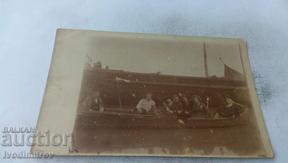 Φωτογραφία Νέοι άνδρες και γυναίκες σε μια βάρκα για εκδρομές