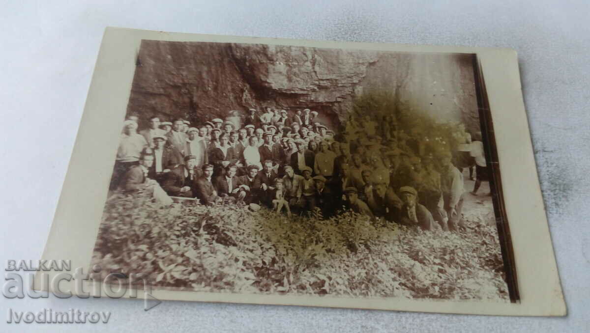 Photo Men women and children in front of a rock
