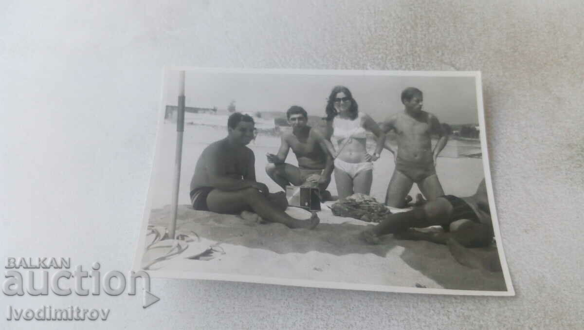 Photo Four men and a woman on the beach