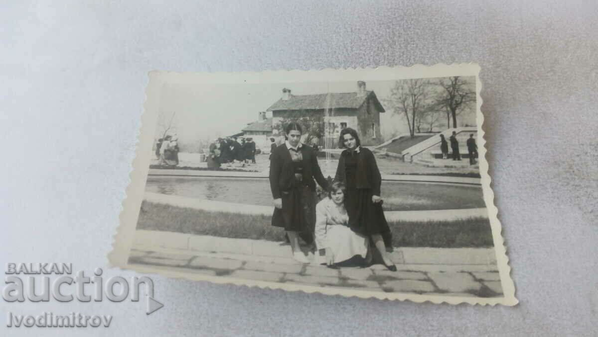 Photo Three young girls in front of a fountain