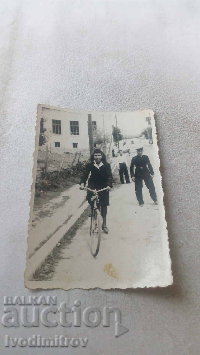Φωτογραφία Νεαρό κορίτσι με ένα εκλεκτής ποιότητας ποδήλατο στο δρόμο