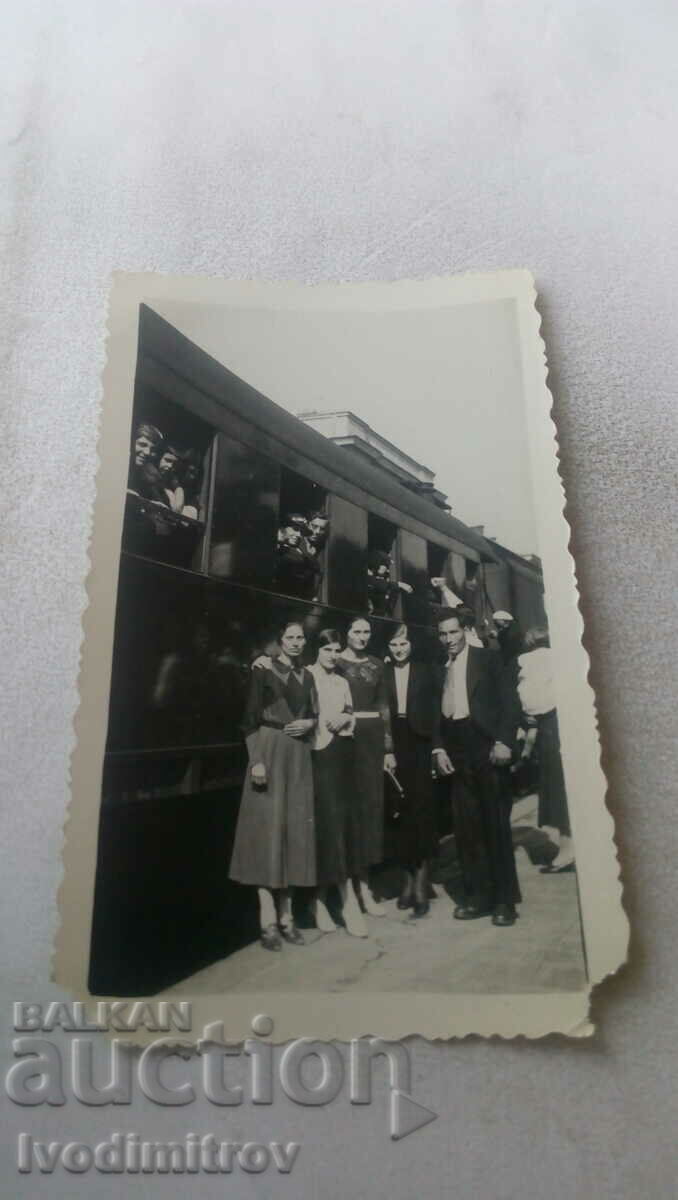 Photo A man and young girls on a platform along the road. wagon