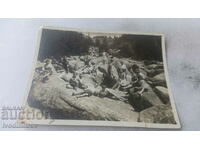 Photo Young men and women on rocky moraines in the mountains