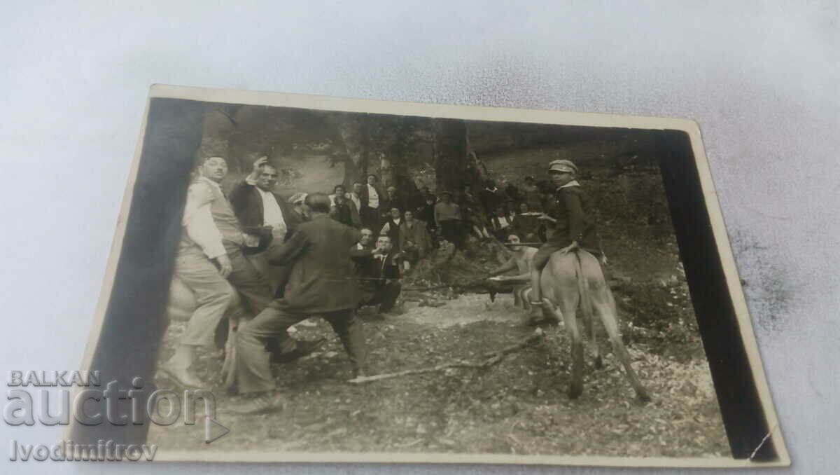 Imagine Bărbați, femei și un băiat cu un măgar la picnic