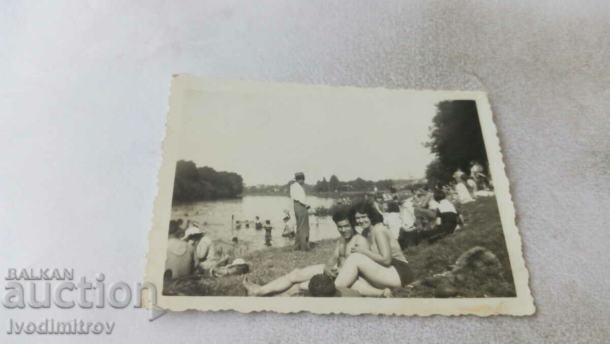 Photo Men and women on a meadow by a river