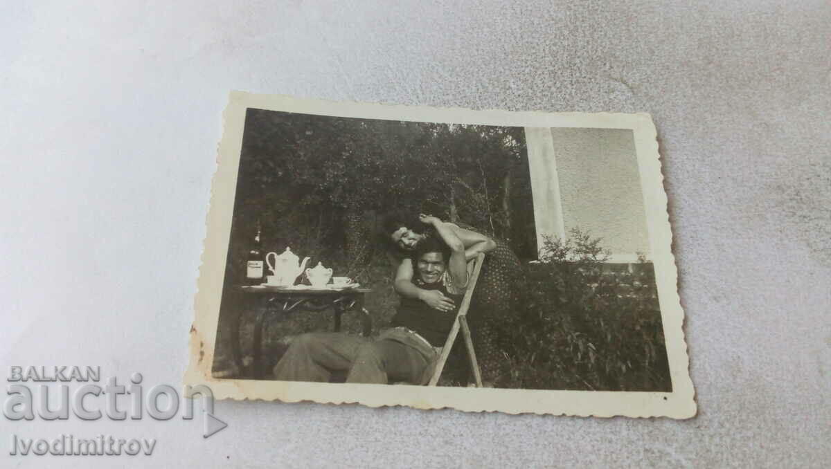 Снимка Мъж и жена в двора на къщата си до масичка