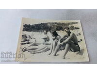 Photo Two young men and two girls on the beach