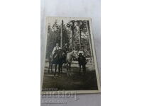 Photo Woman and two boys on horses in the forest