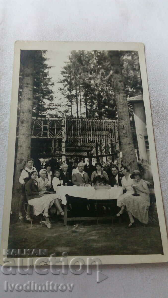 Снимка Мъже и жени на по питие около маса