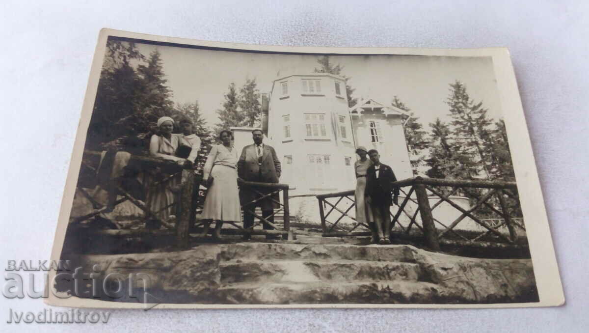 Fotografie Un bărbat, trei femei și doi băieți în fața unei cabane din munți