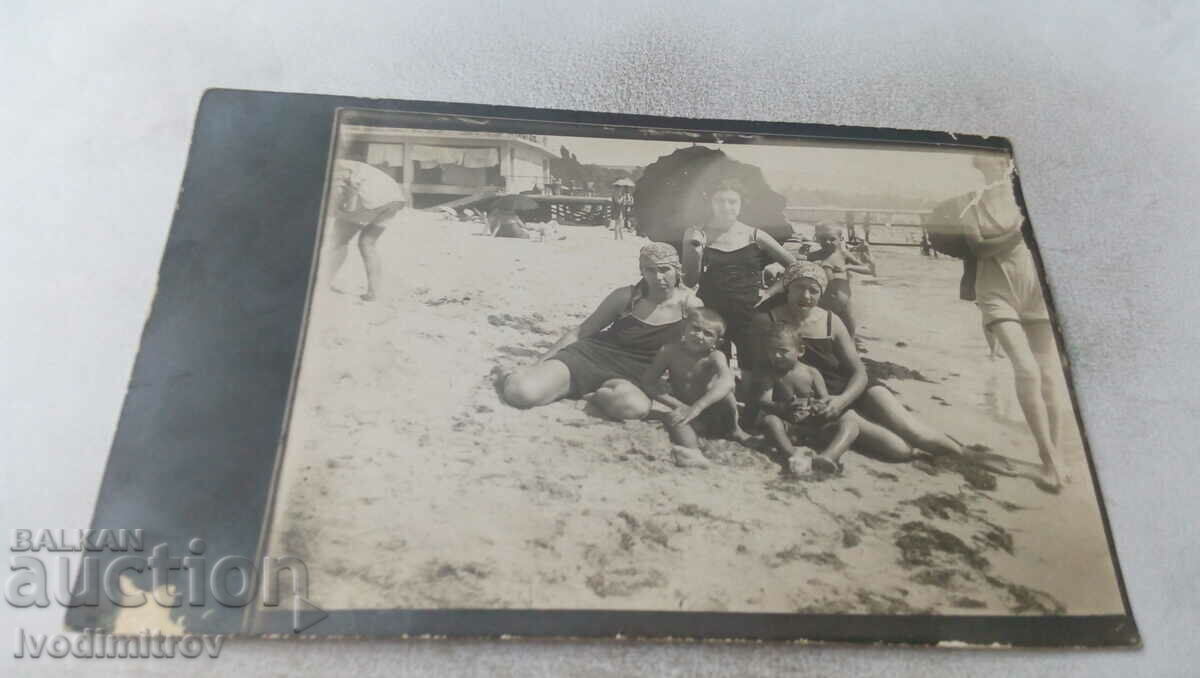 Foto Trei femei și copii pe plajă
