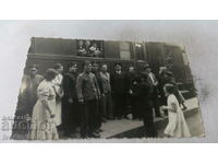 Photo Railwaymen and passengers past passenger cars