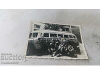Φωτογραφία Άνδρες και γυναίκες μπροστά από ένα vintage λεωφορείο