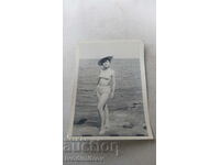Снимка Младо момиче с ретро бански на скала покрай морето