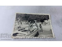 Снимка Две жени в лодка и малко момченце на брега