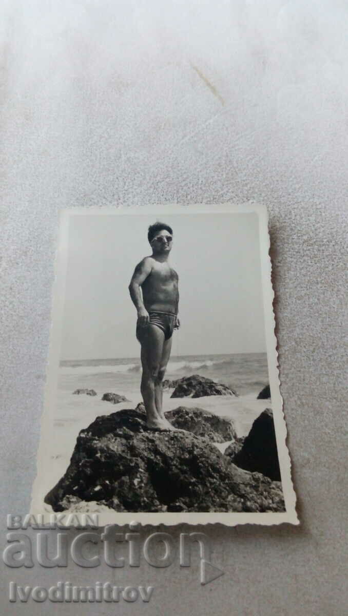Φωτογραφία Άνθρωπος σε βράχο δίπλα στη θάλασσα