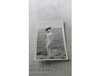 Φωτογραφία Νεαρή γυναίκα με καπέλο σε βράχο δίπλα στη θάλασσα