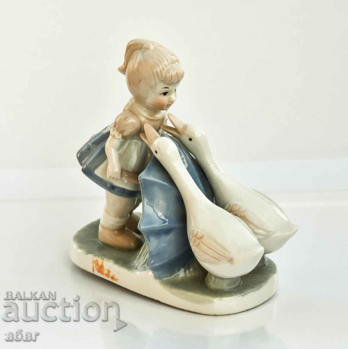 A figurine of a girl with two swans