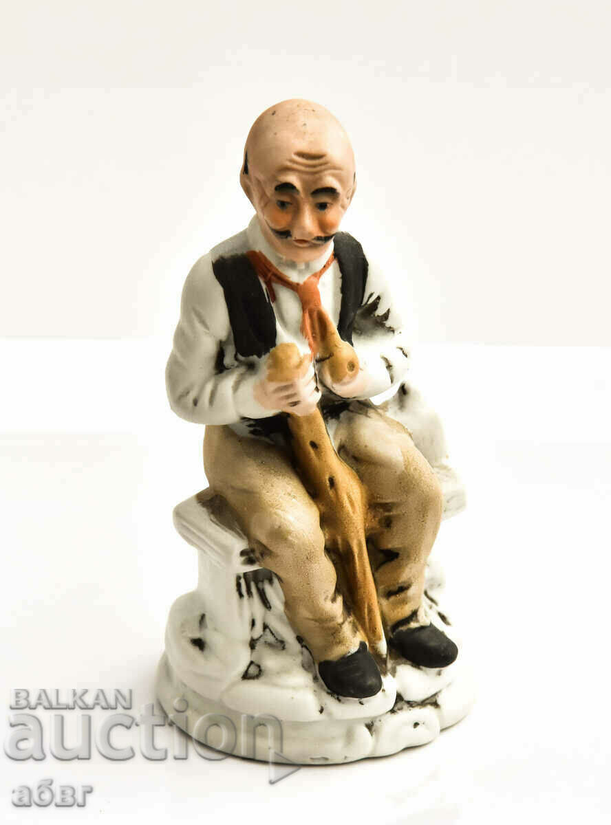 Figure of an old man seated on a bench