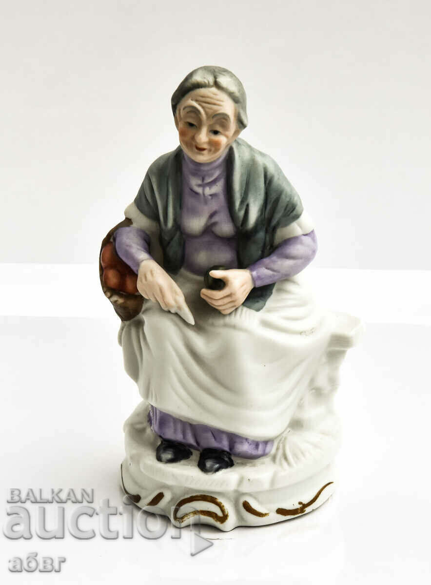 Figura unei bătrâne care stă pe o bancă