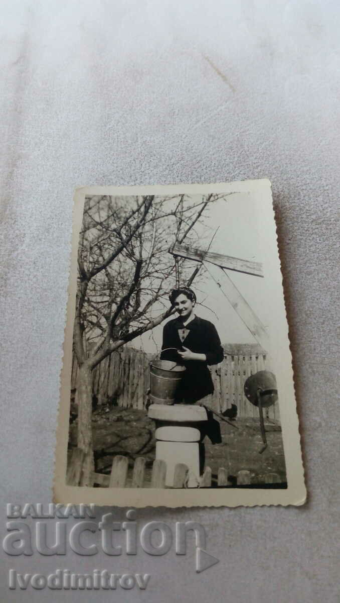 Снимка Млада жена с кофа до кладенец